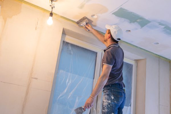 Worker make repairs in new apartment. Man plaster walls and ceilings. High quality photo